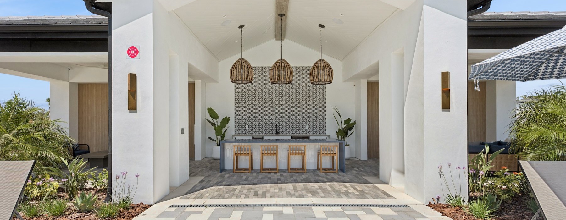 Quick access to state-of-the-art amenities an outdoor community kitchen area with an island and chairs
