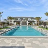 a pool with chairs and a building in the background