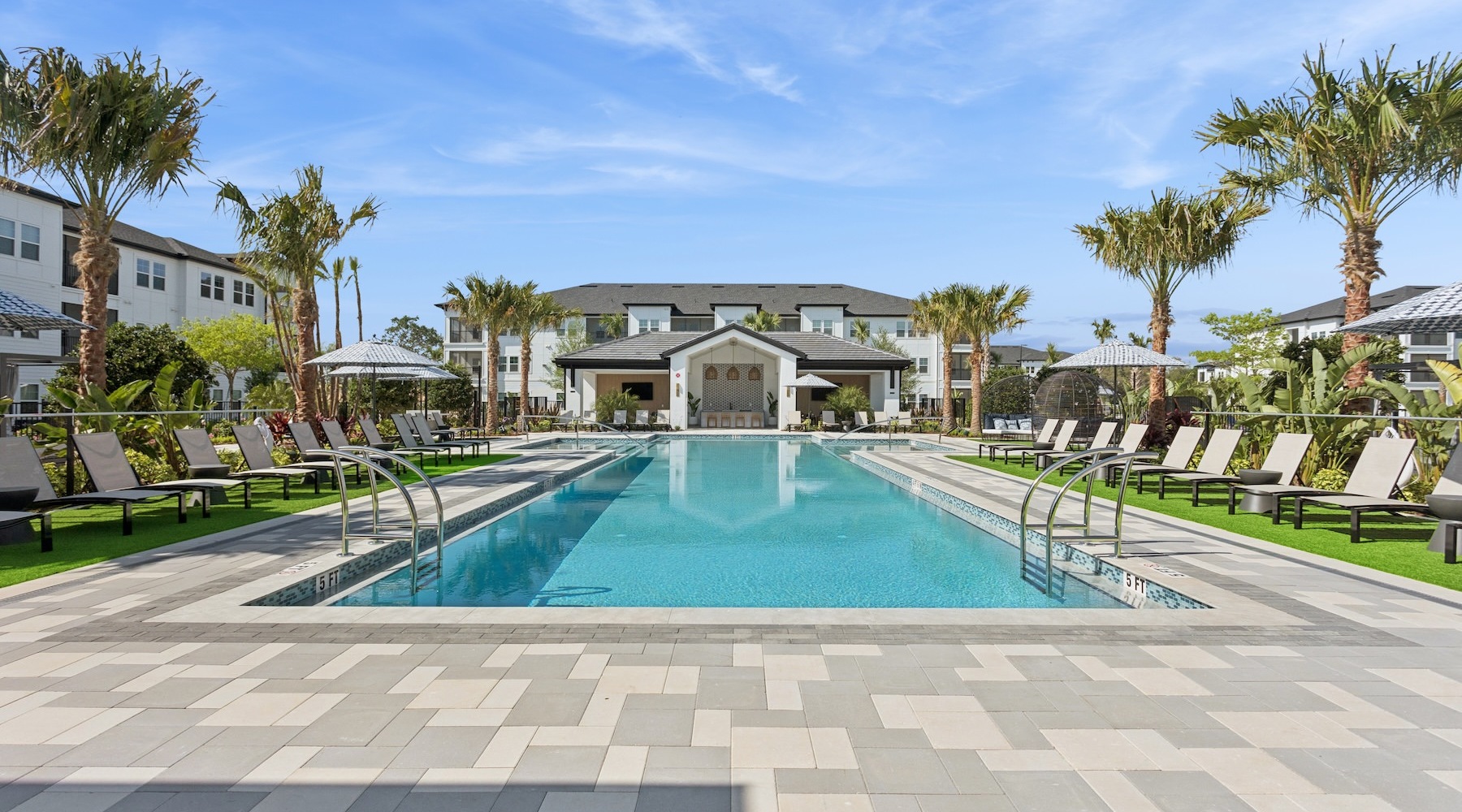 a pool with chairs and a building in the background